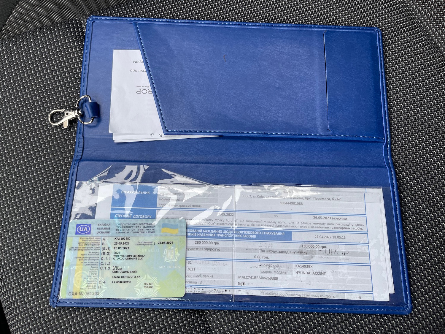 a blue wallet with a key and a plastic bag with a key