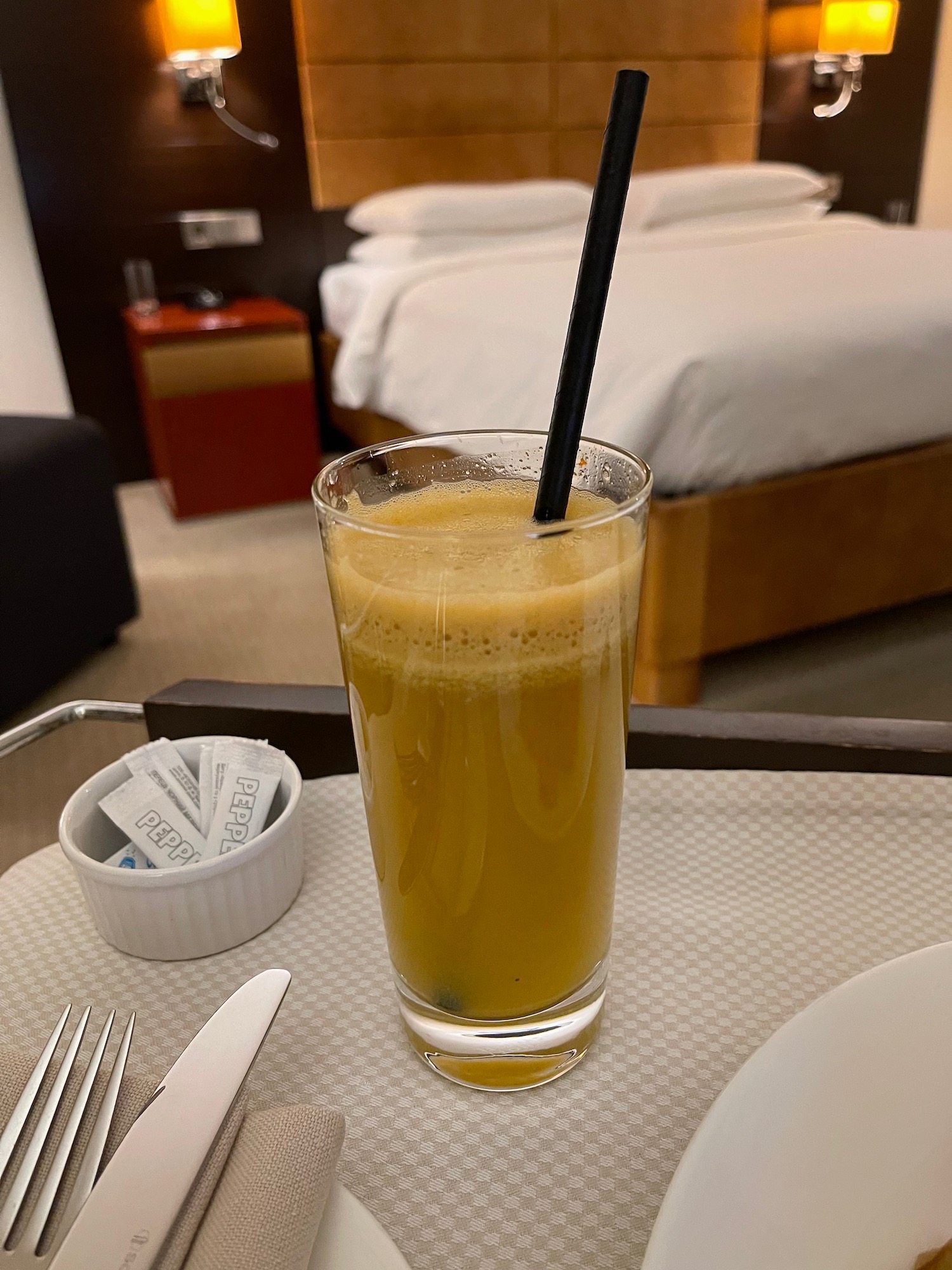 a glass of orange juice with a straw