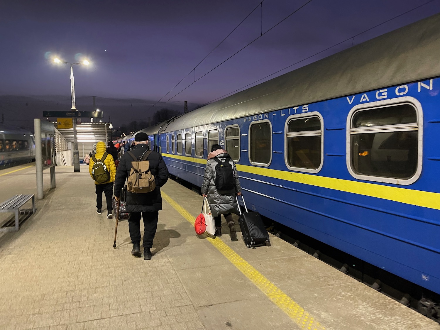 people walking on a platform with a train