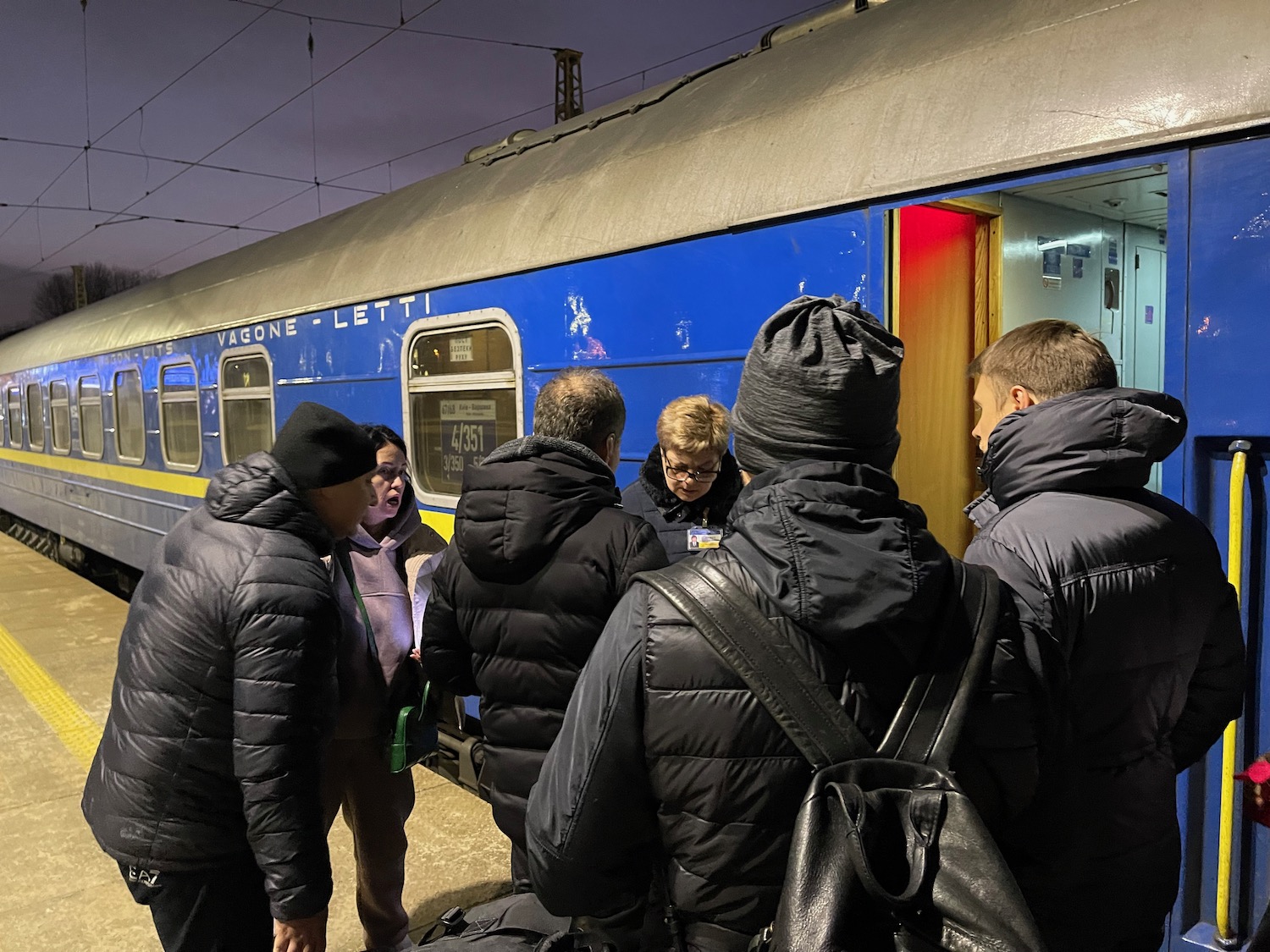 a group of people standing next to a train