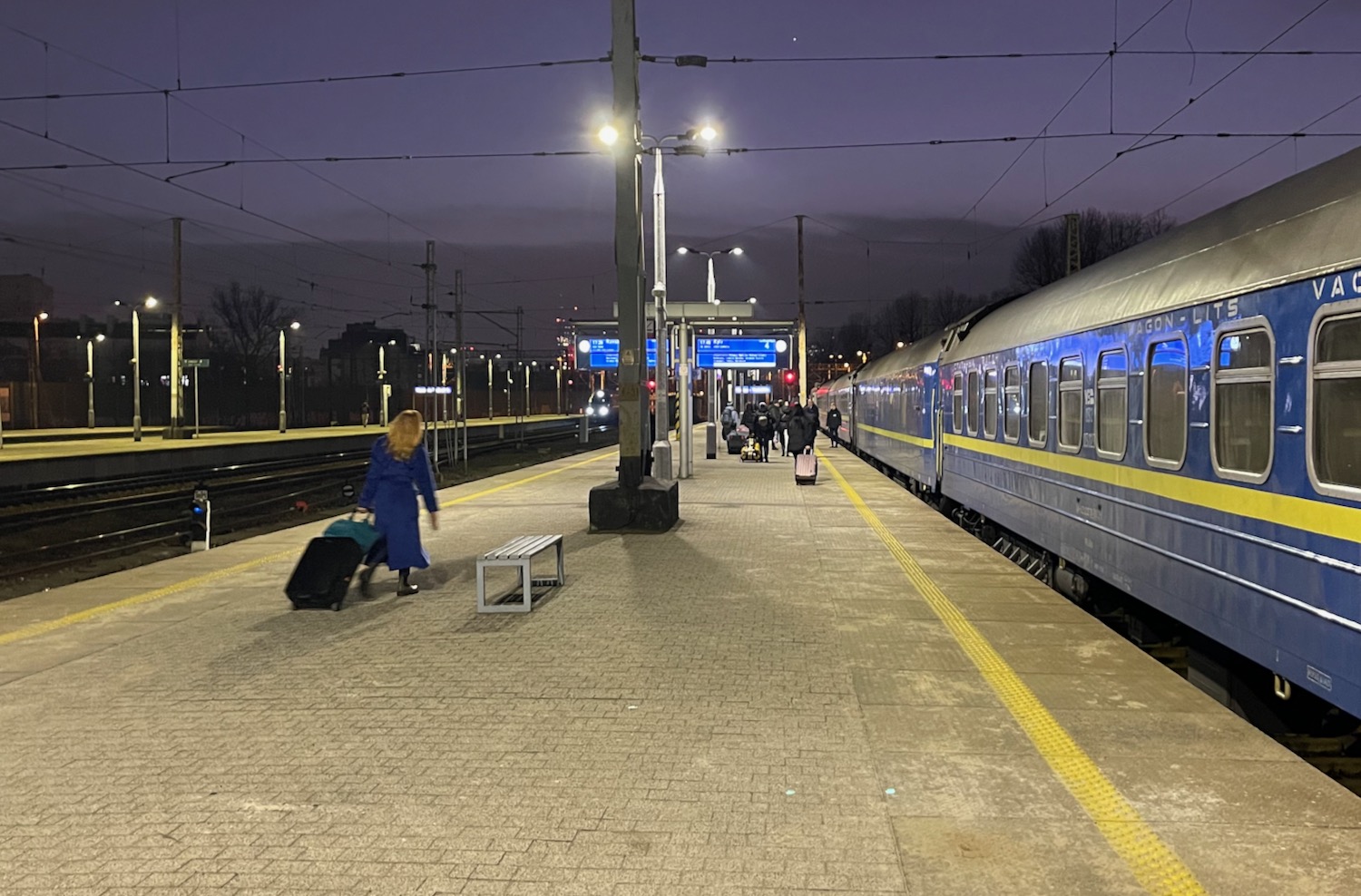a woman pulling luggage at a train station