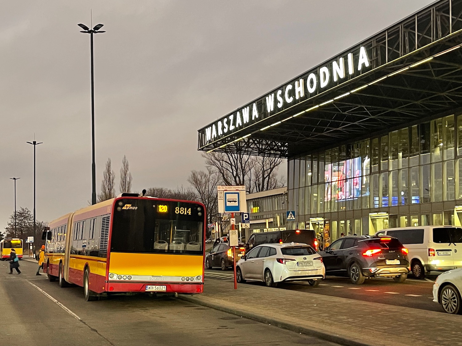 a bus and cars parked in front of a building