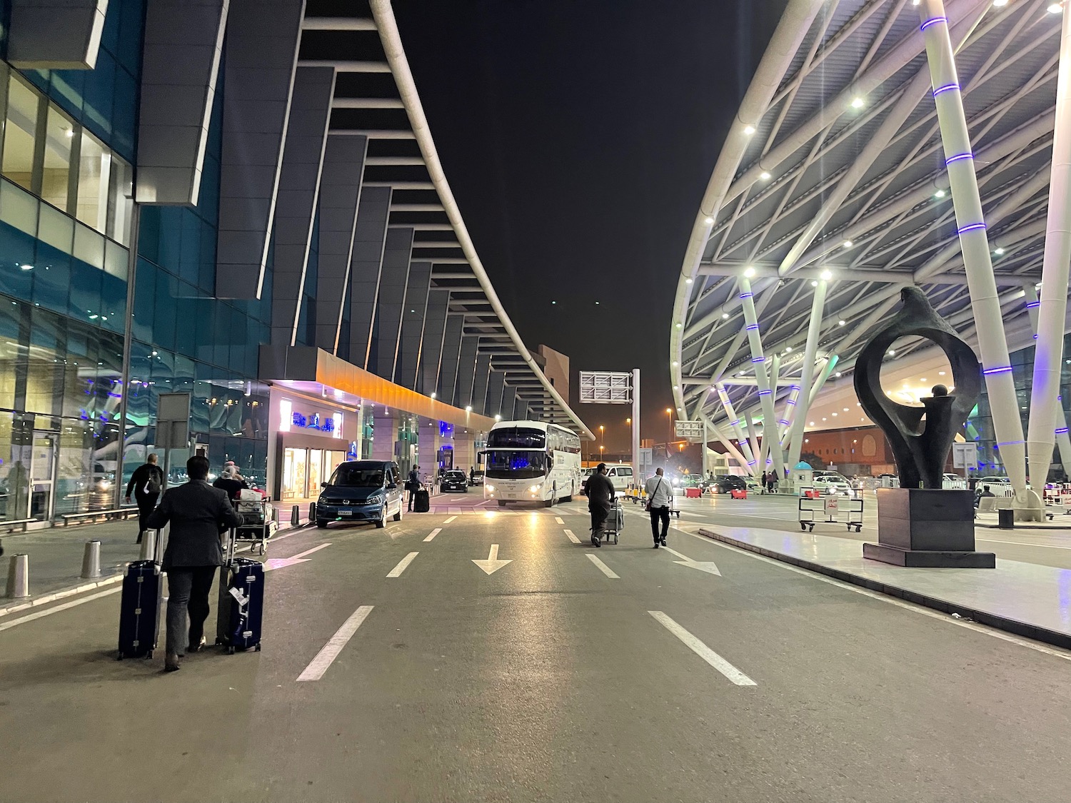 a bus station with people and cars