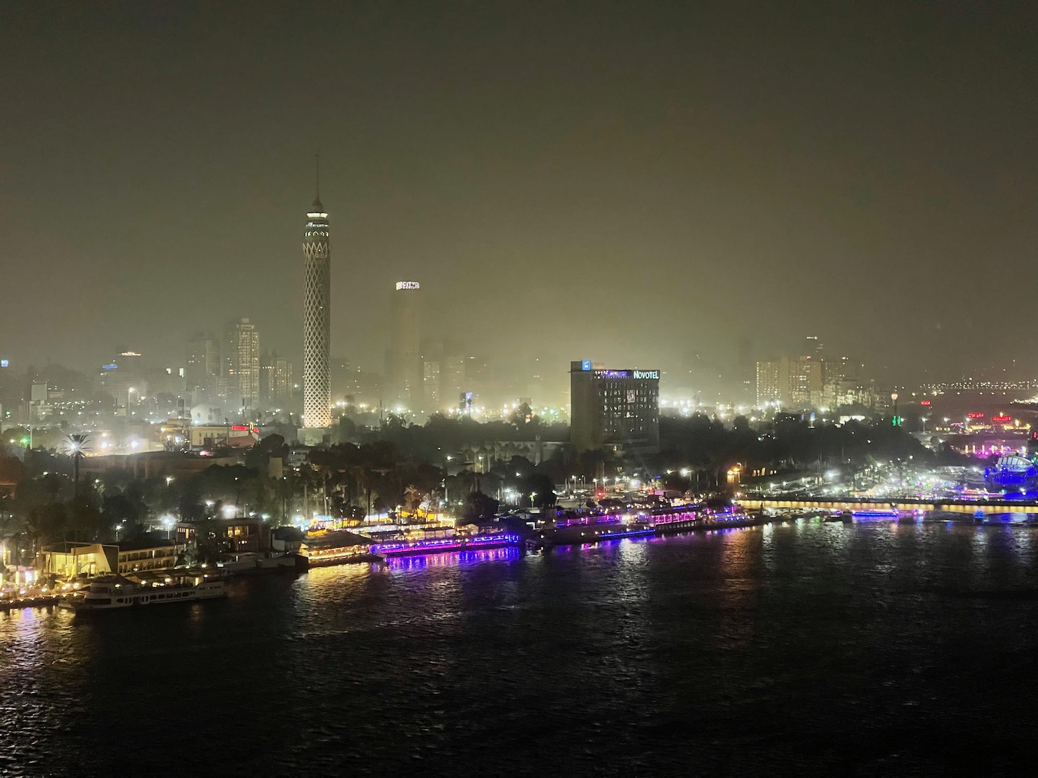 a city at night with lights on the water