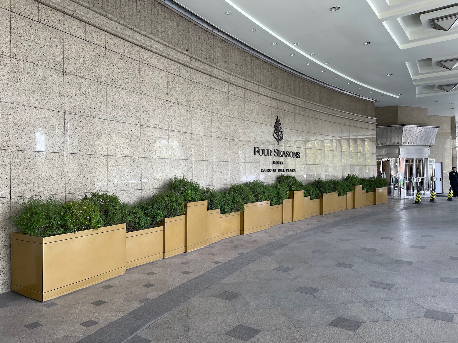 a building with a sign and plants