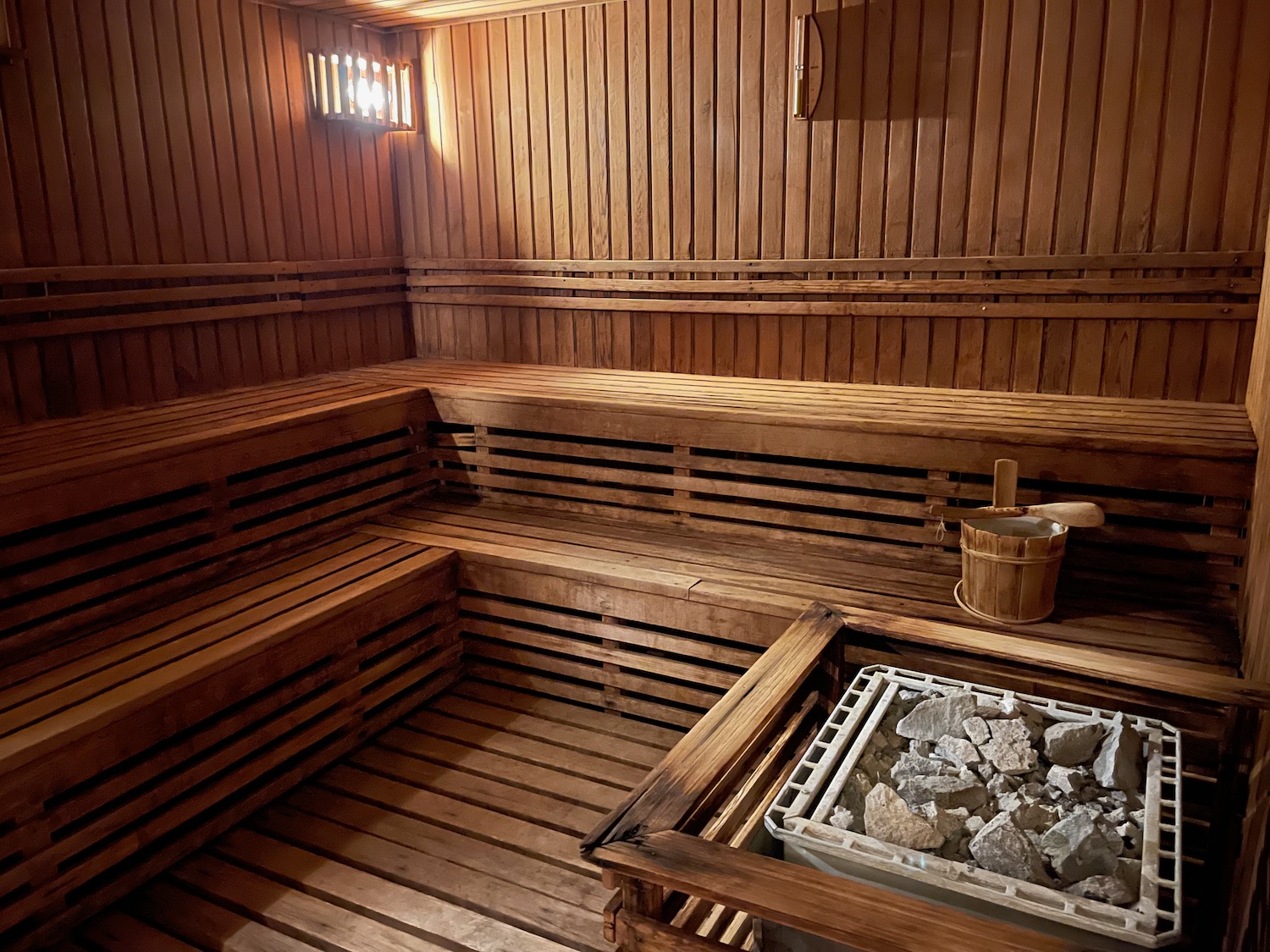 a wooden sauna with a bucket and rocks