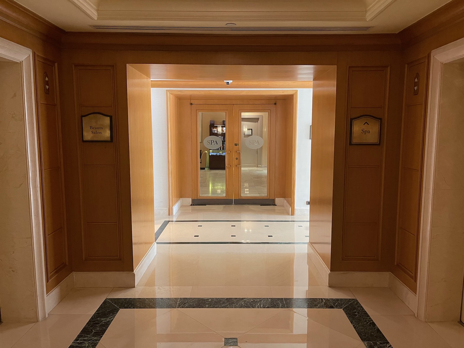 a hallway with wood doors and marble floor