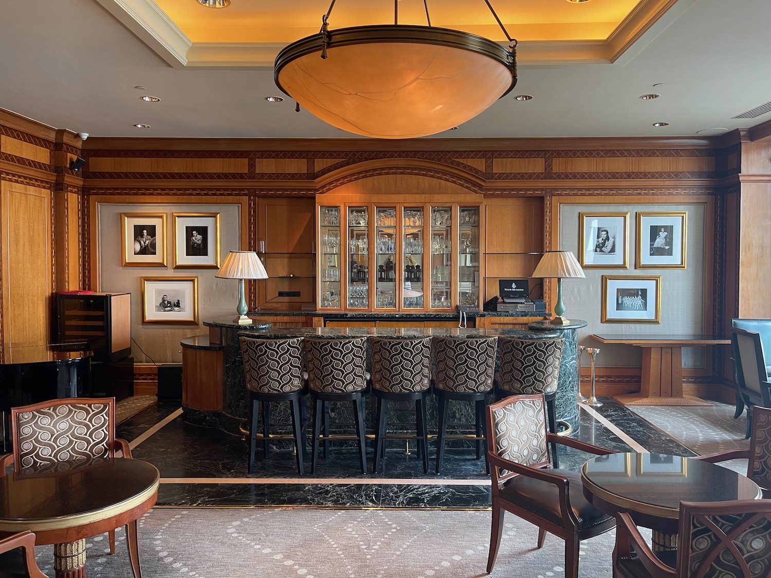 a bar with chairs and a chandelier