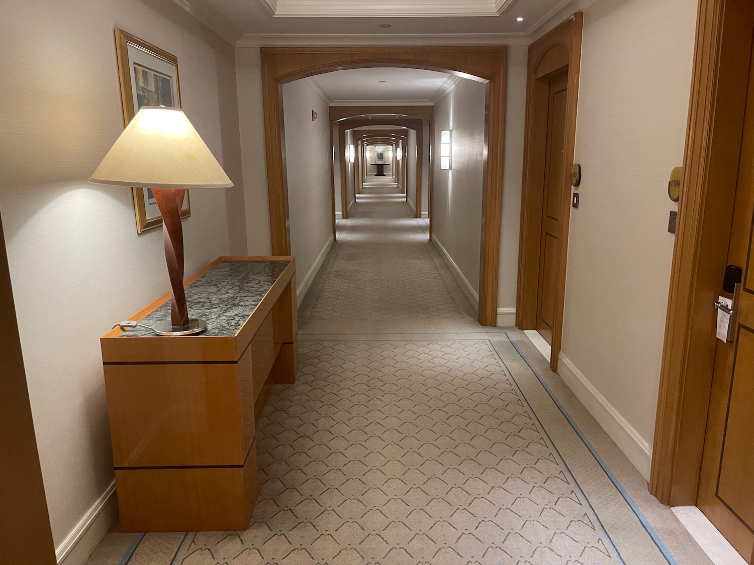 a hallway with a table and lamp