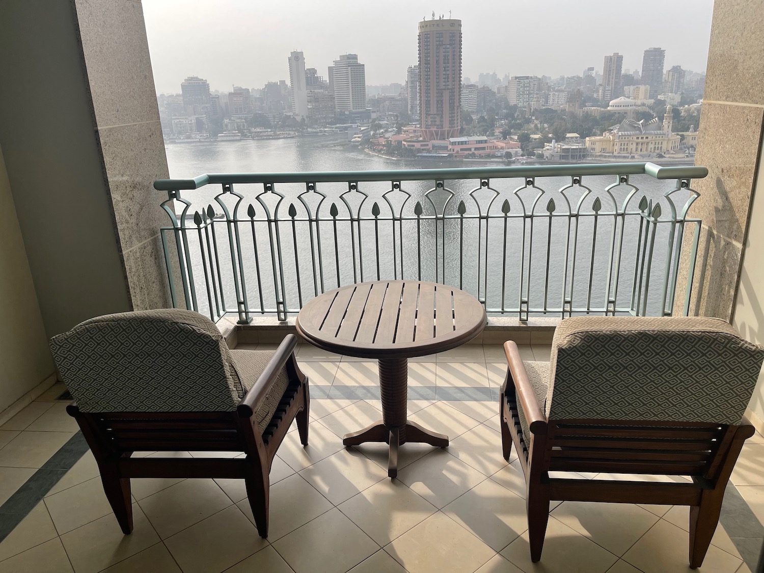 a table and chairs on a balcony overlooking a city