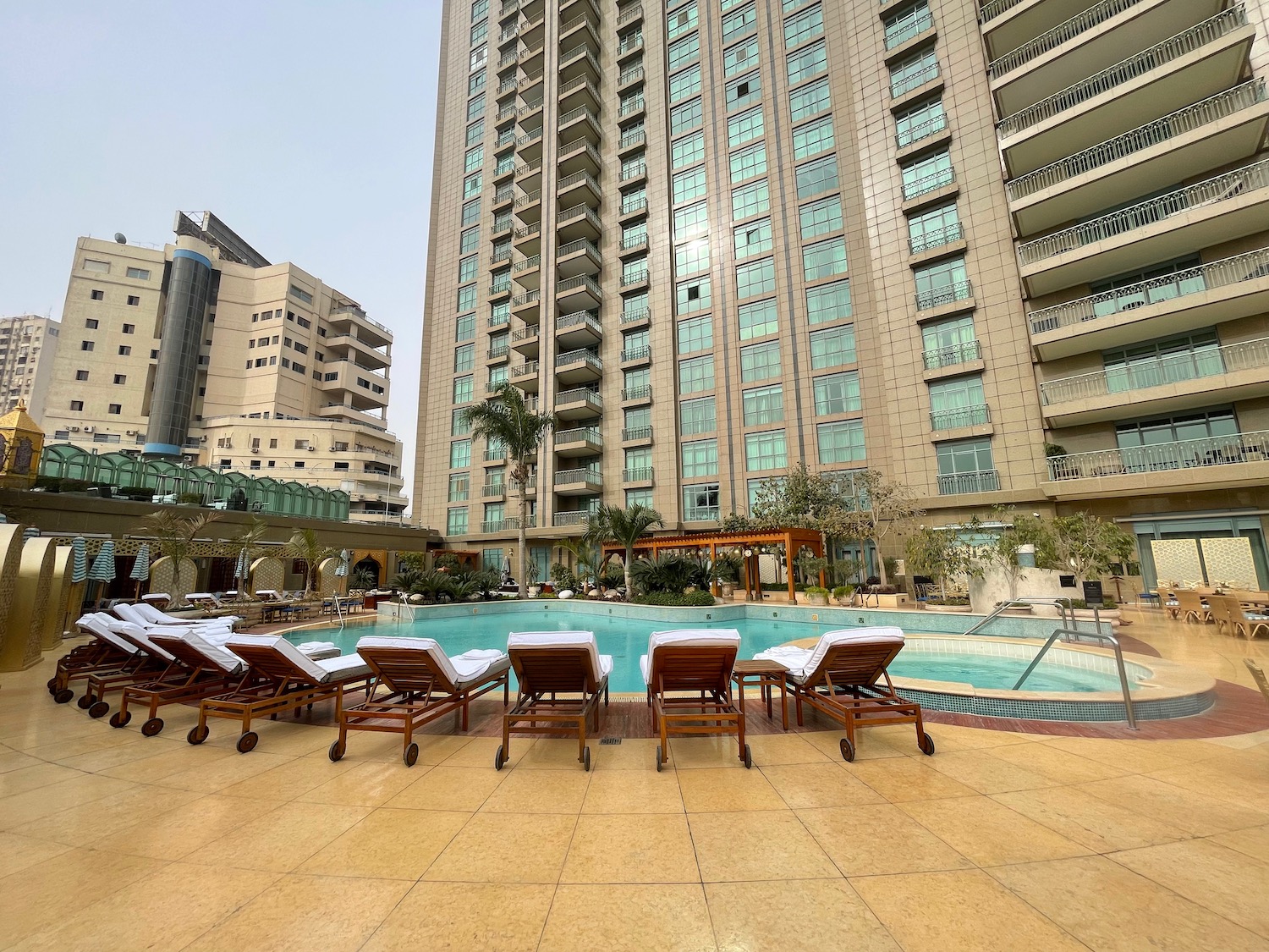 a pool with chairs and a building in the background