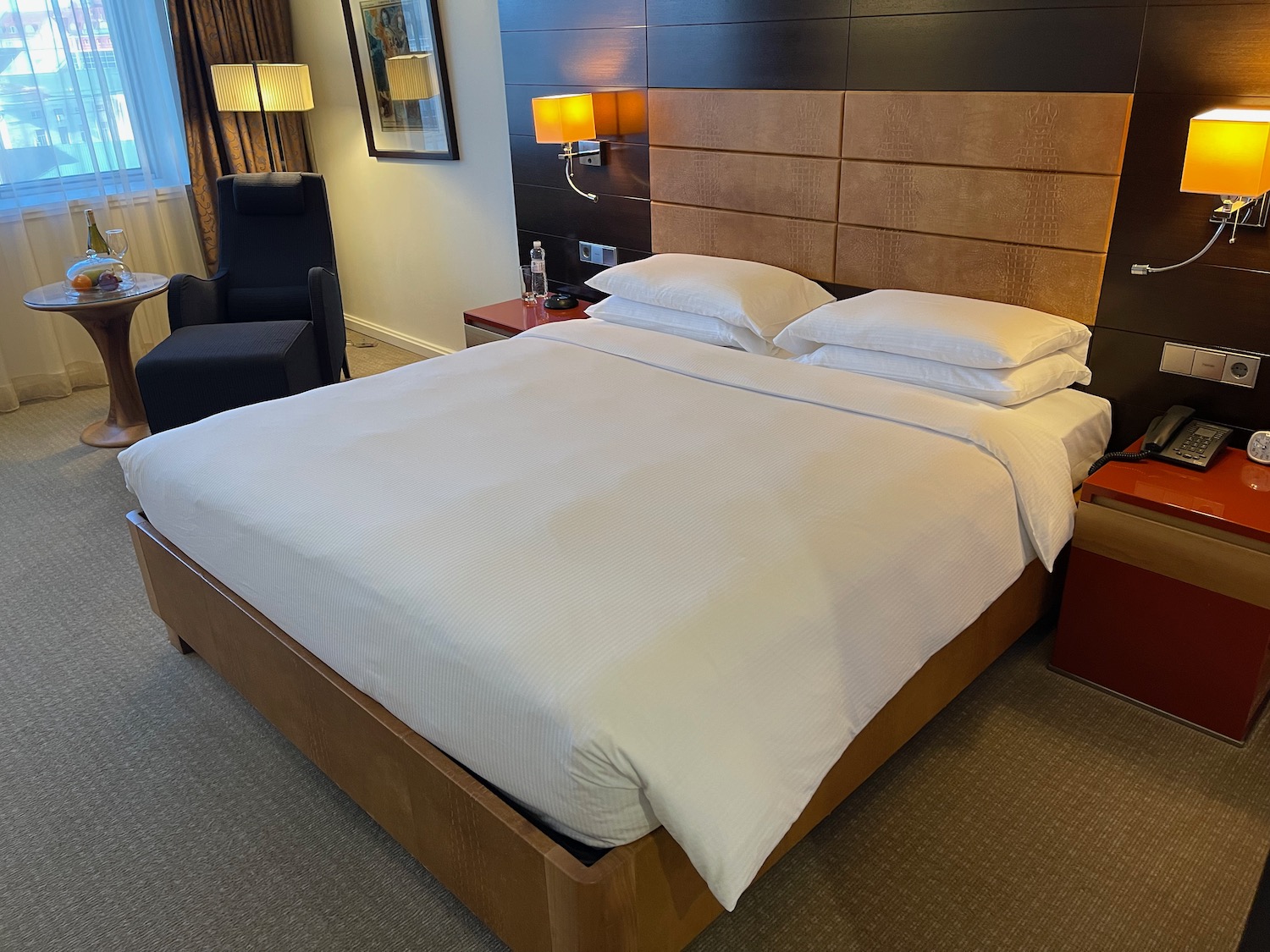 a bed with white sheets and pillows in a room