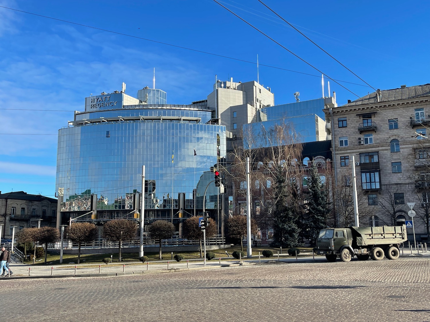 a large building with a glass wall and a truck on the side