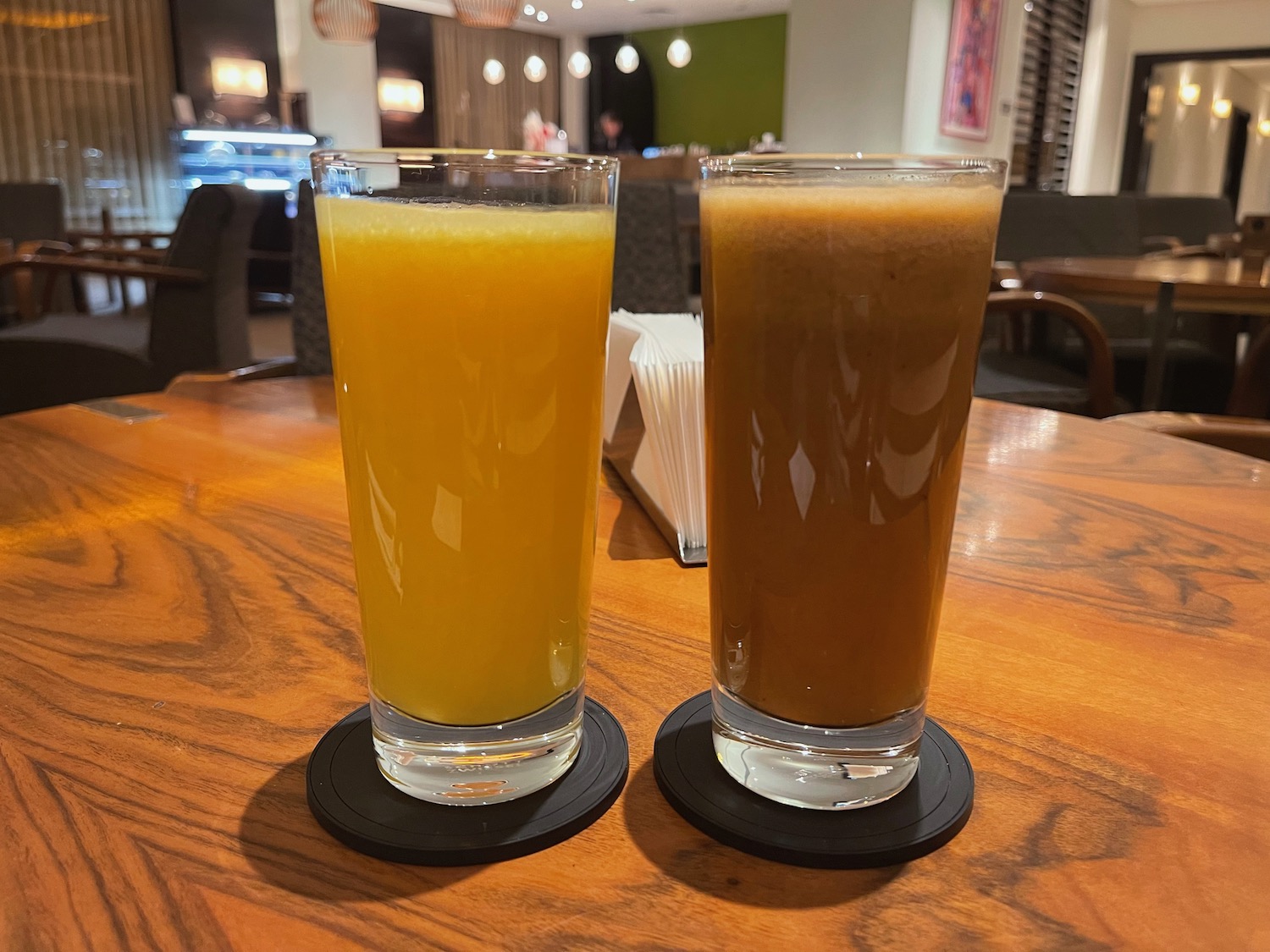 two glasses of orange and brown liquid on a table