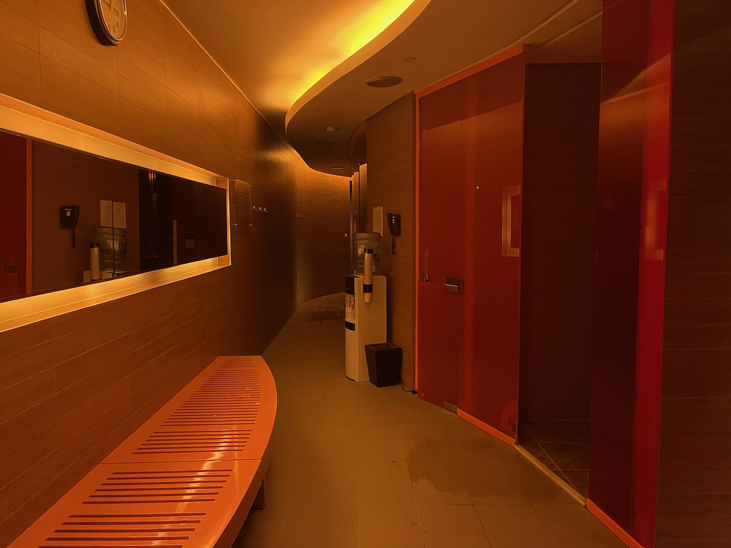 a hallway with a bench and red doors