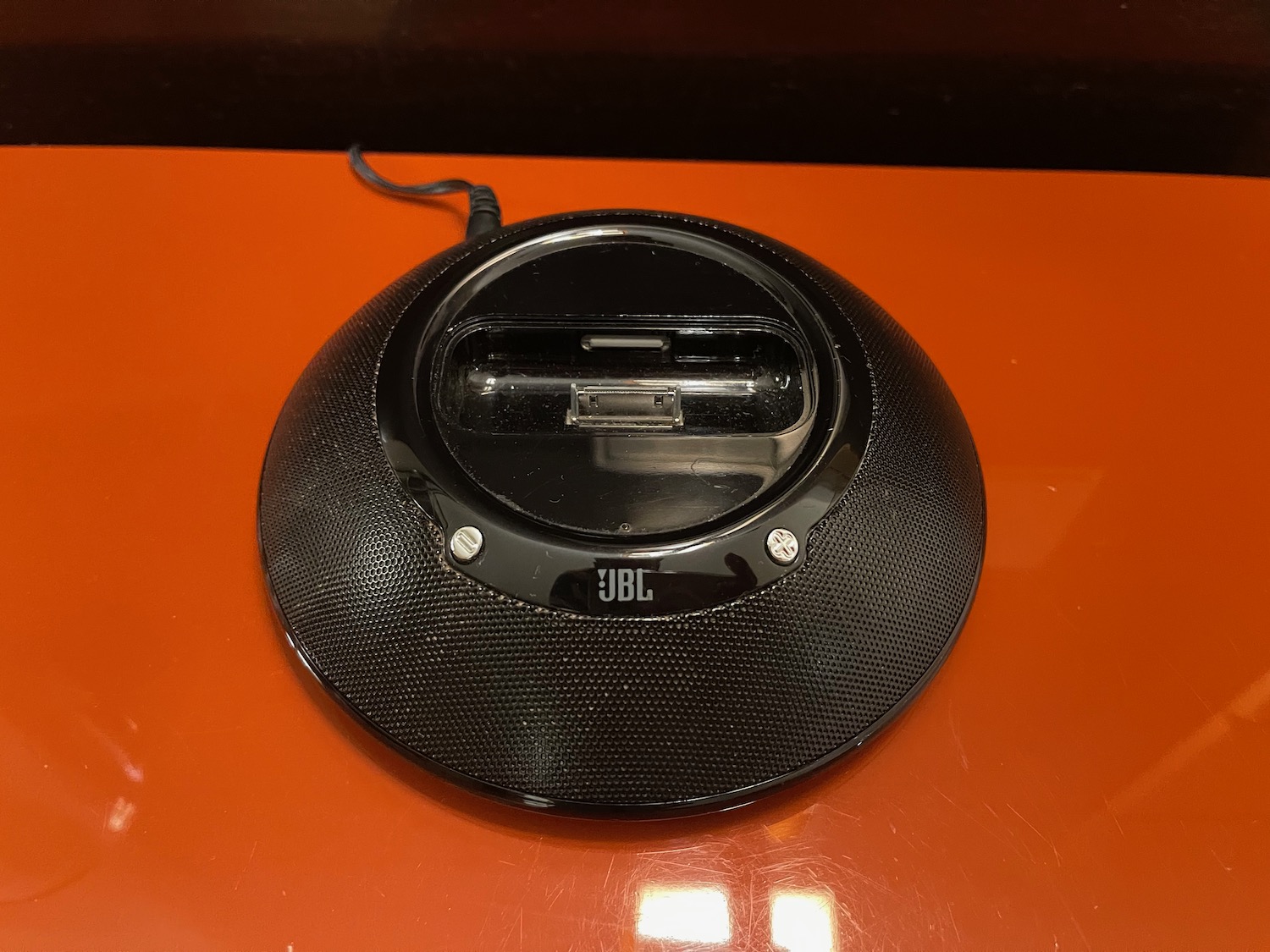 a black speaker on a orange surface