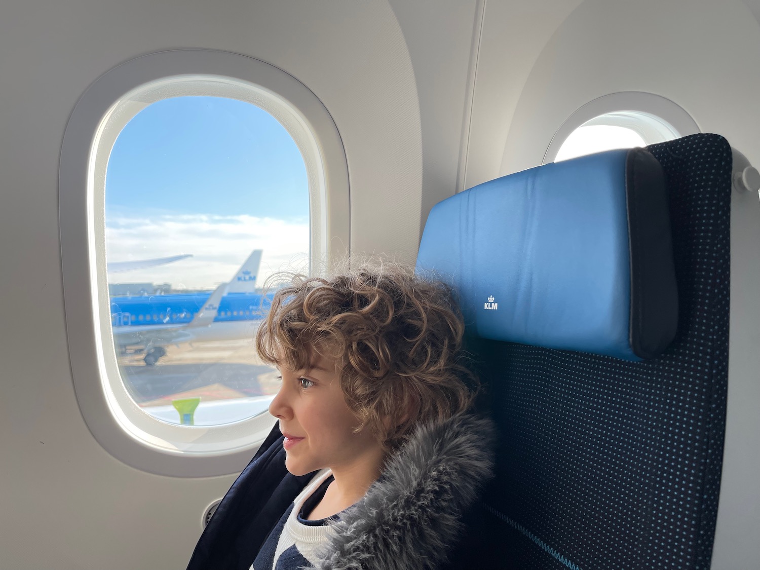 a child sitting in a seat on an airplane