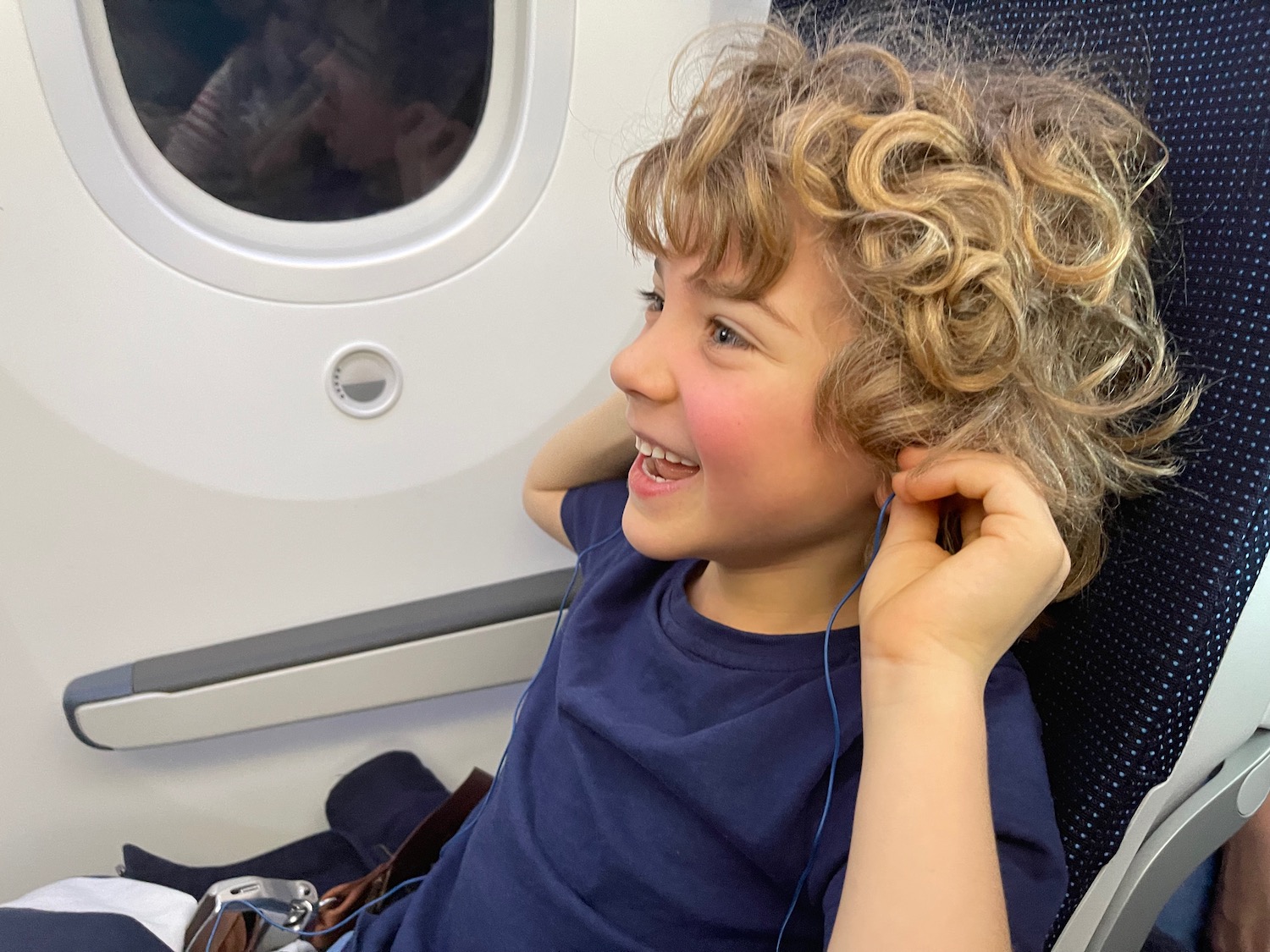a child sitting in an airplane with earphones