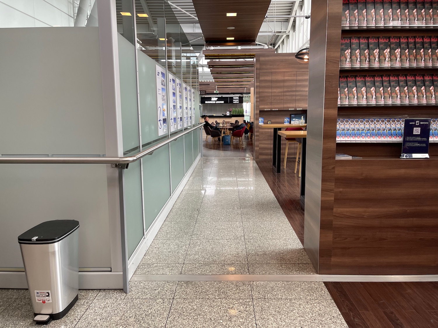 a hallway with a glass wall and shelves