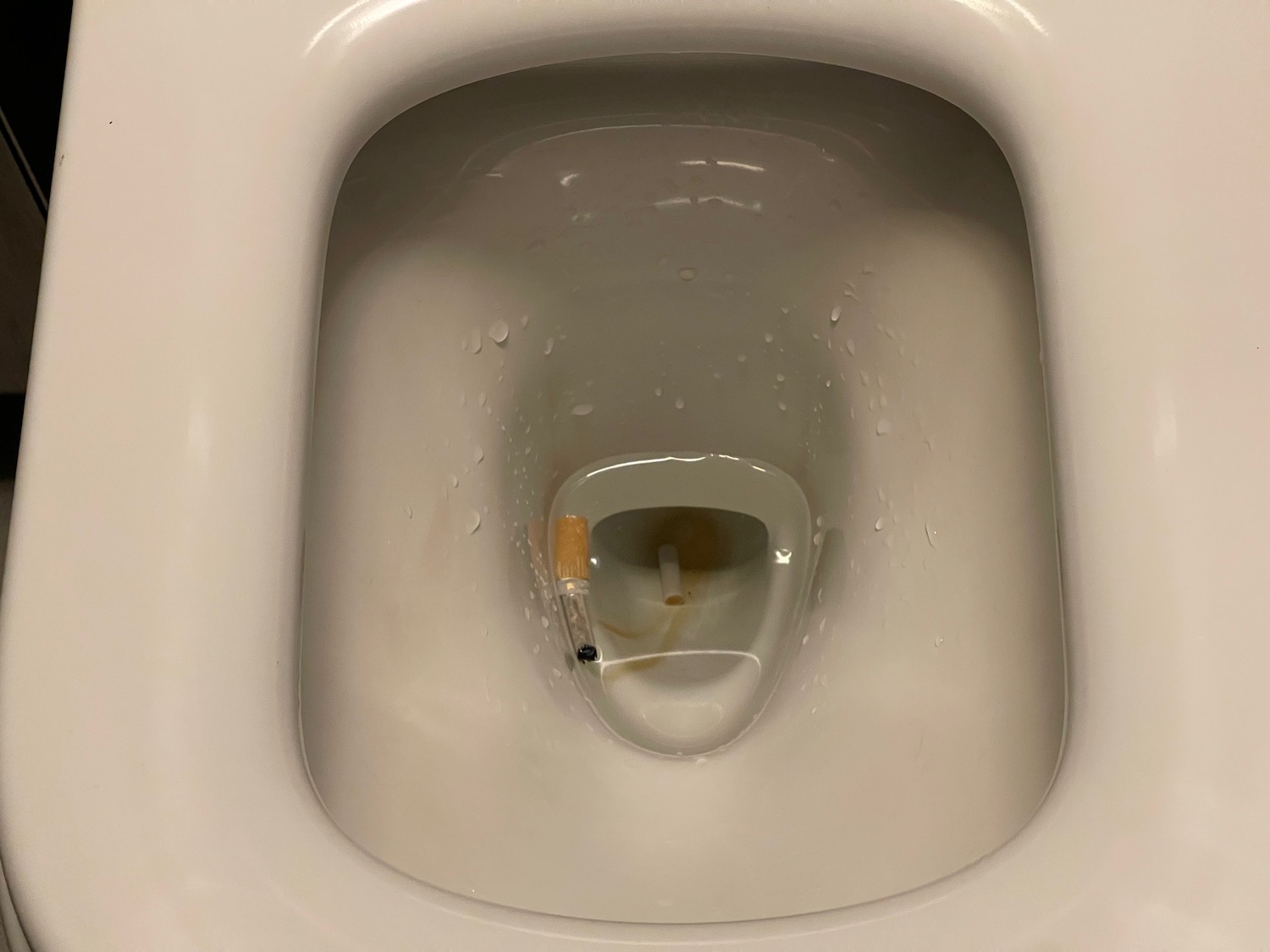 a toilet bowl with a cigarette in it