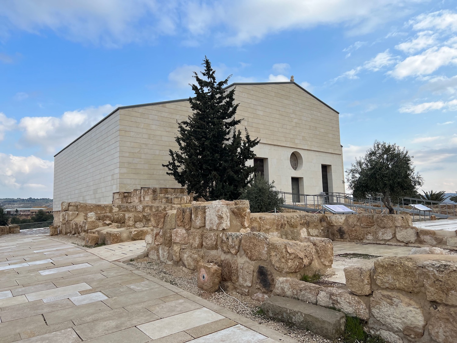 a building with stone walls and trees