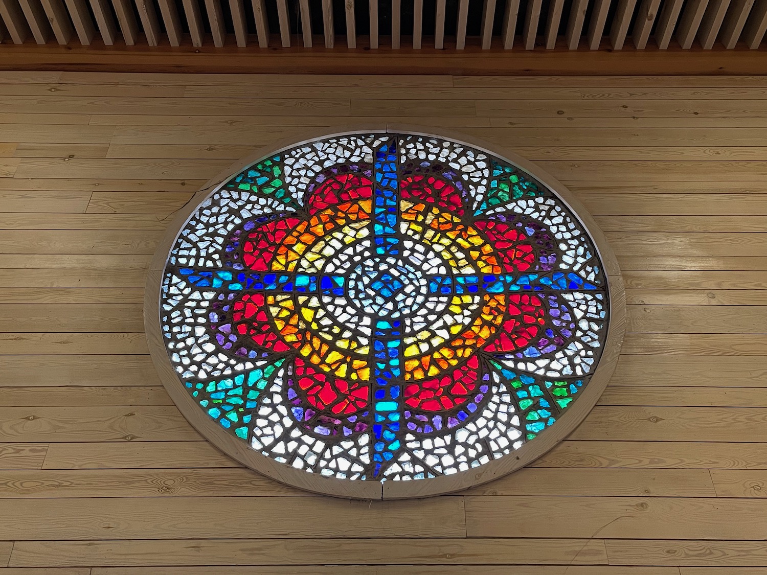 a circular stained glass window on a wood floor