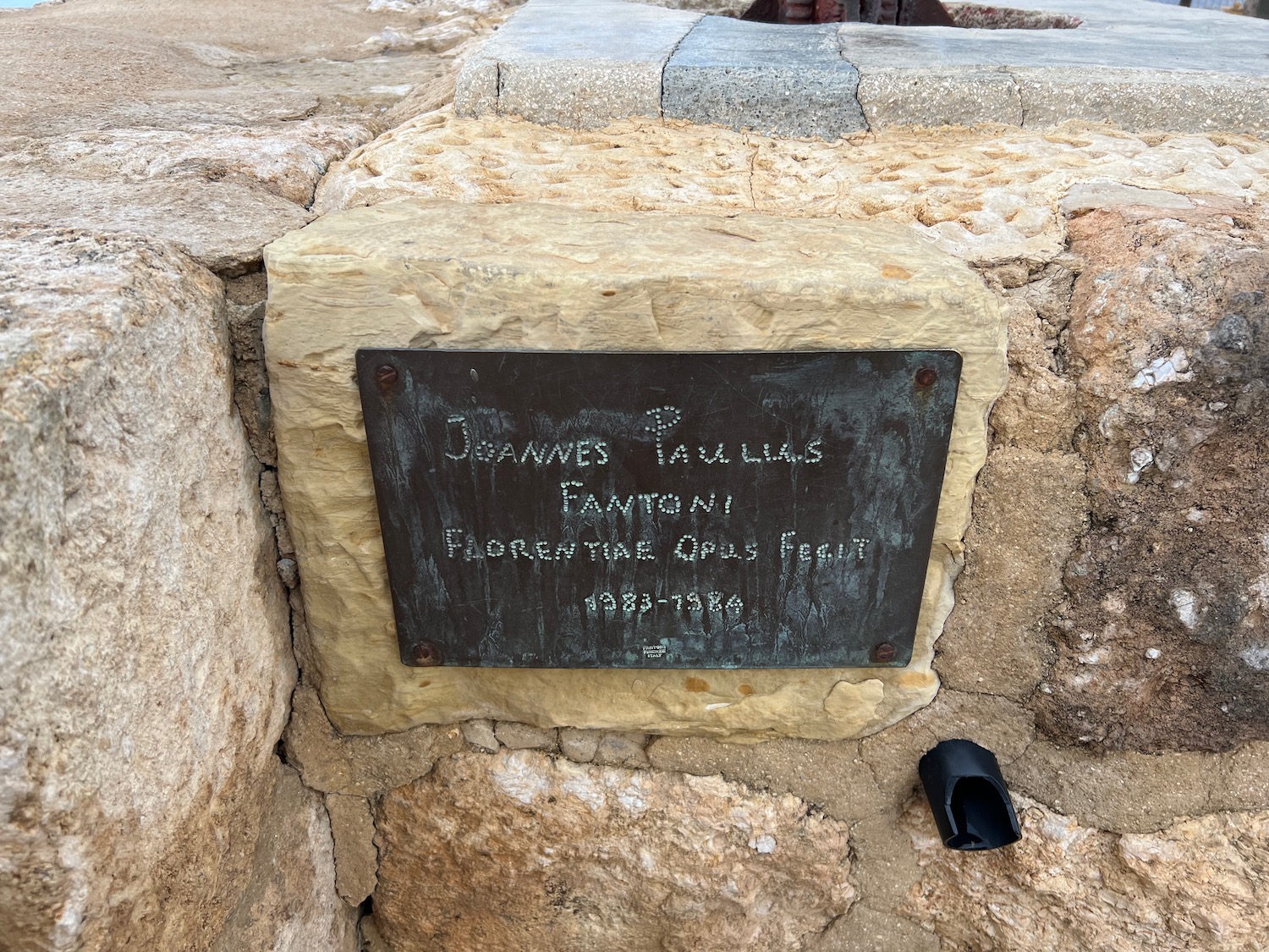 a sign on a stone wall