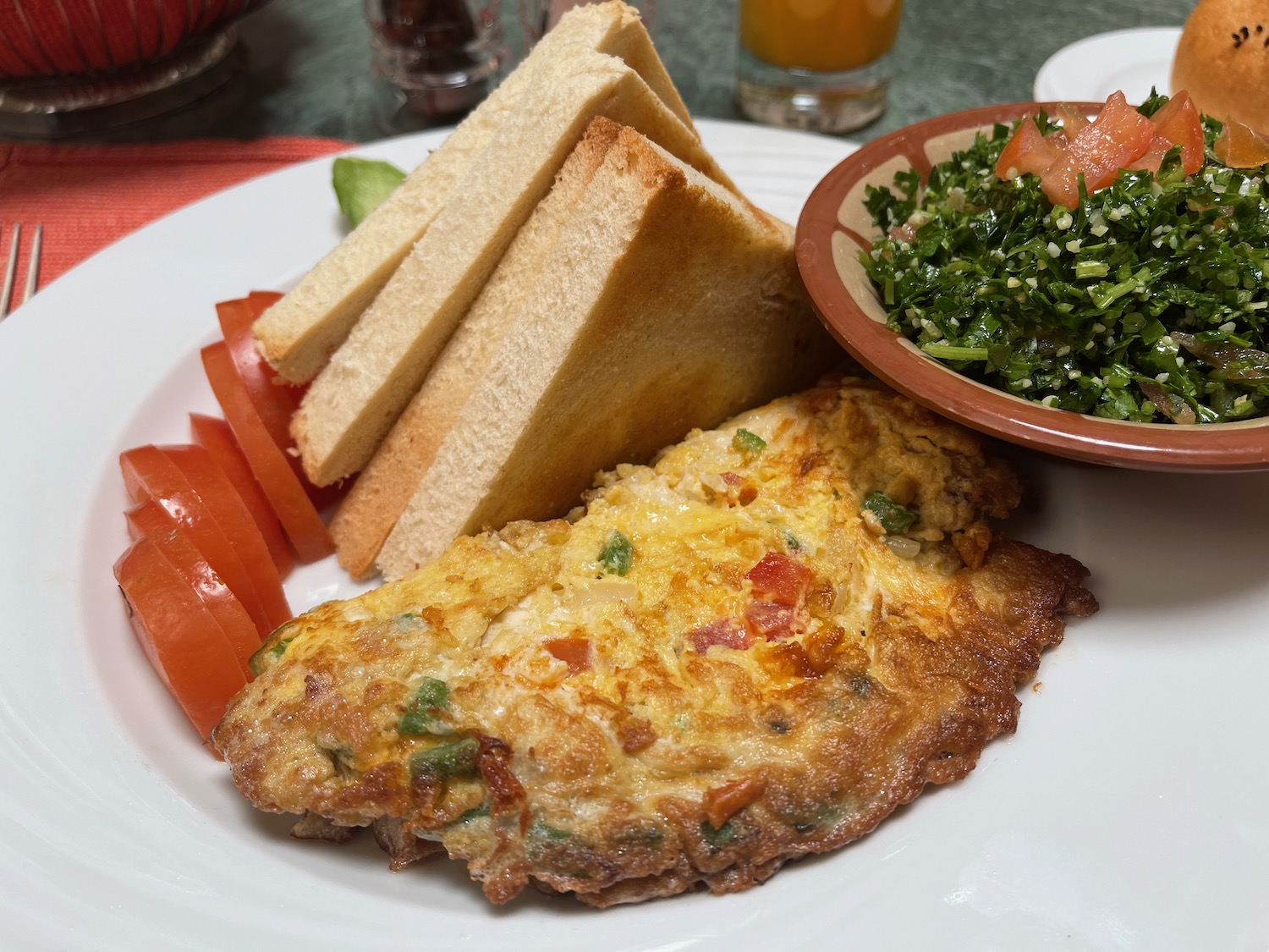 a plate of food with a side of bread and a bowl of salad