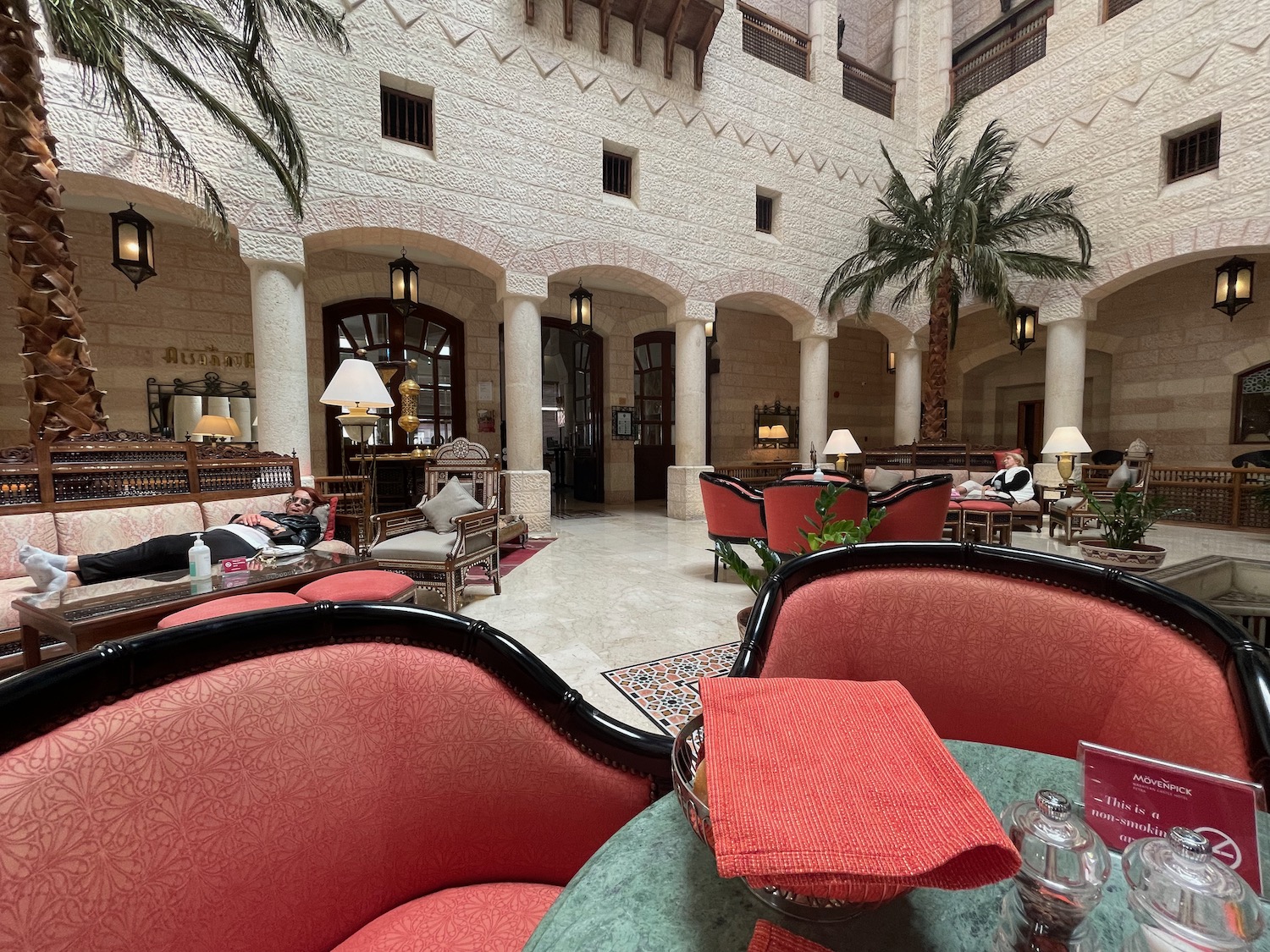 a room with a palm tree and chairs