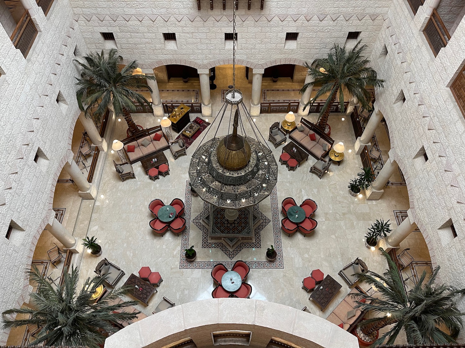 a room with palm trees and a chandelier