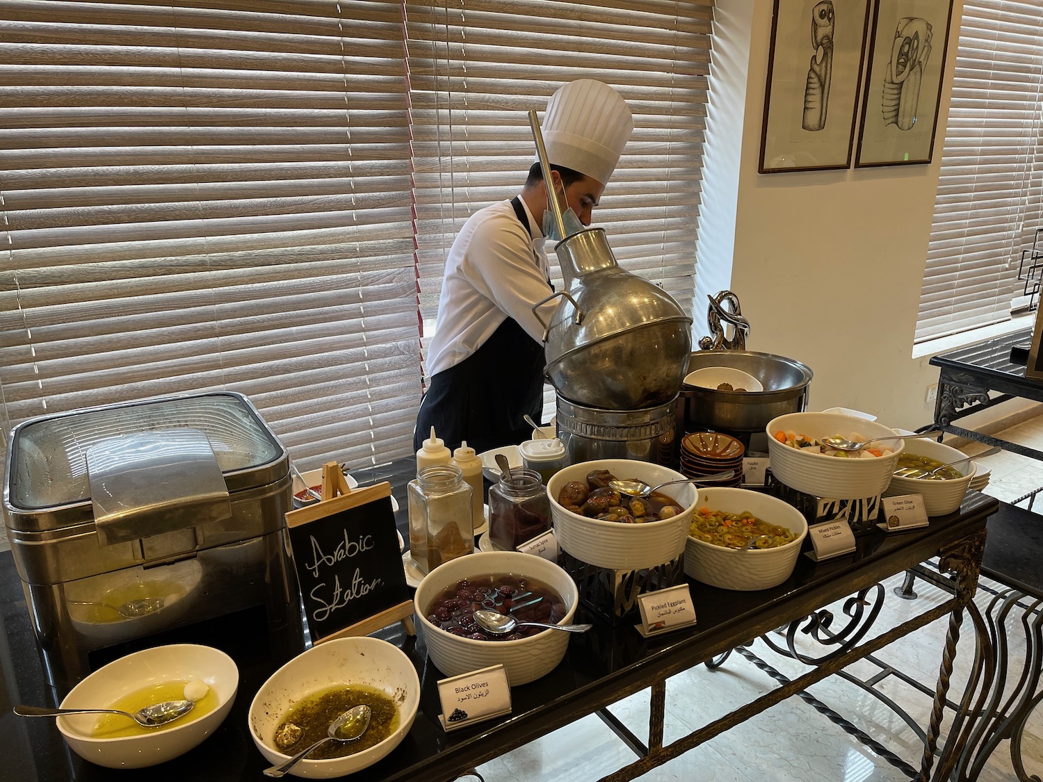 a chef standing behind a table with food