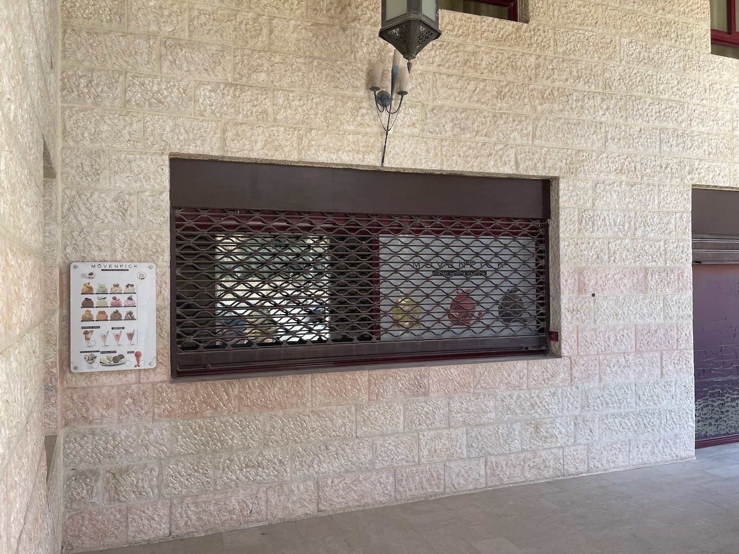 a window with a metal grate on a brick wall