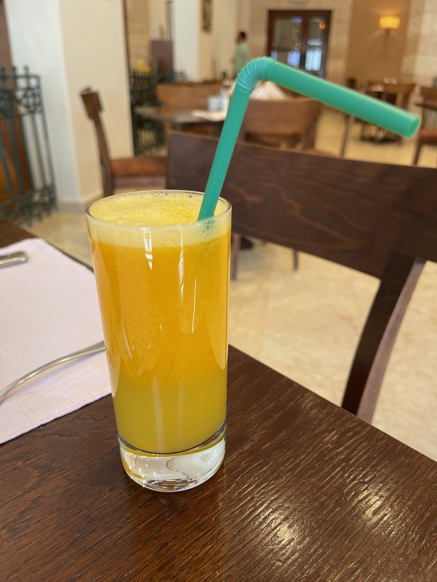 a glass of orange juice with a straw