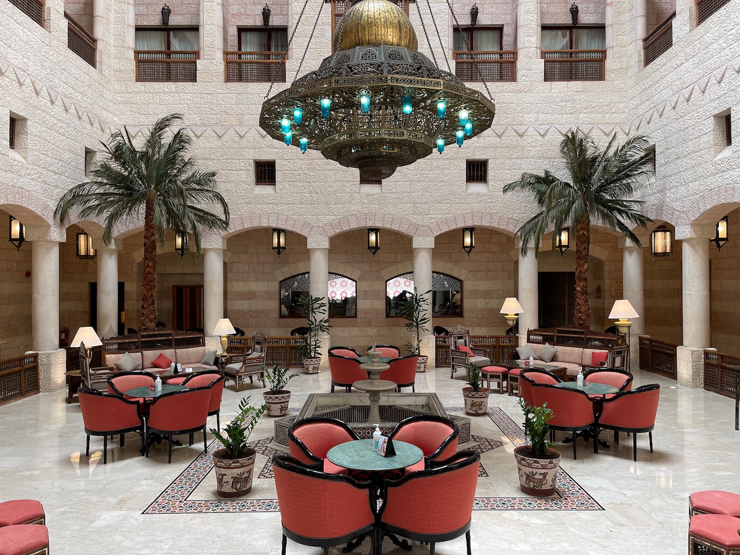 a room with tables and chairs and palm trees