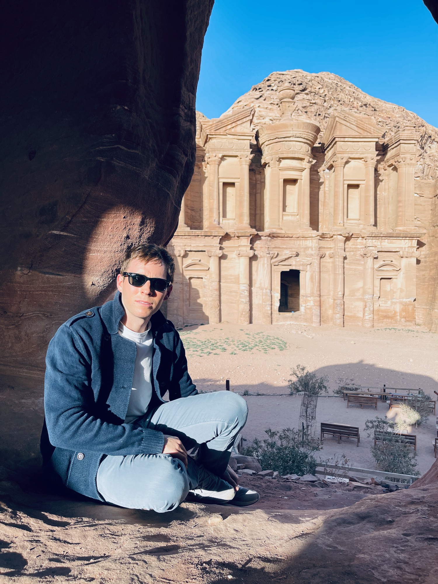 a man sitting in front of a rock formation