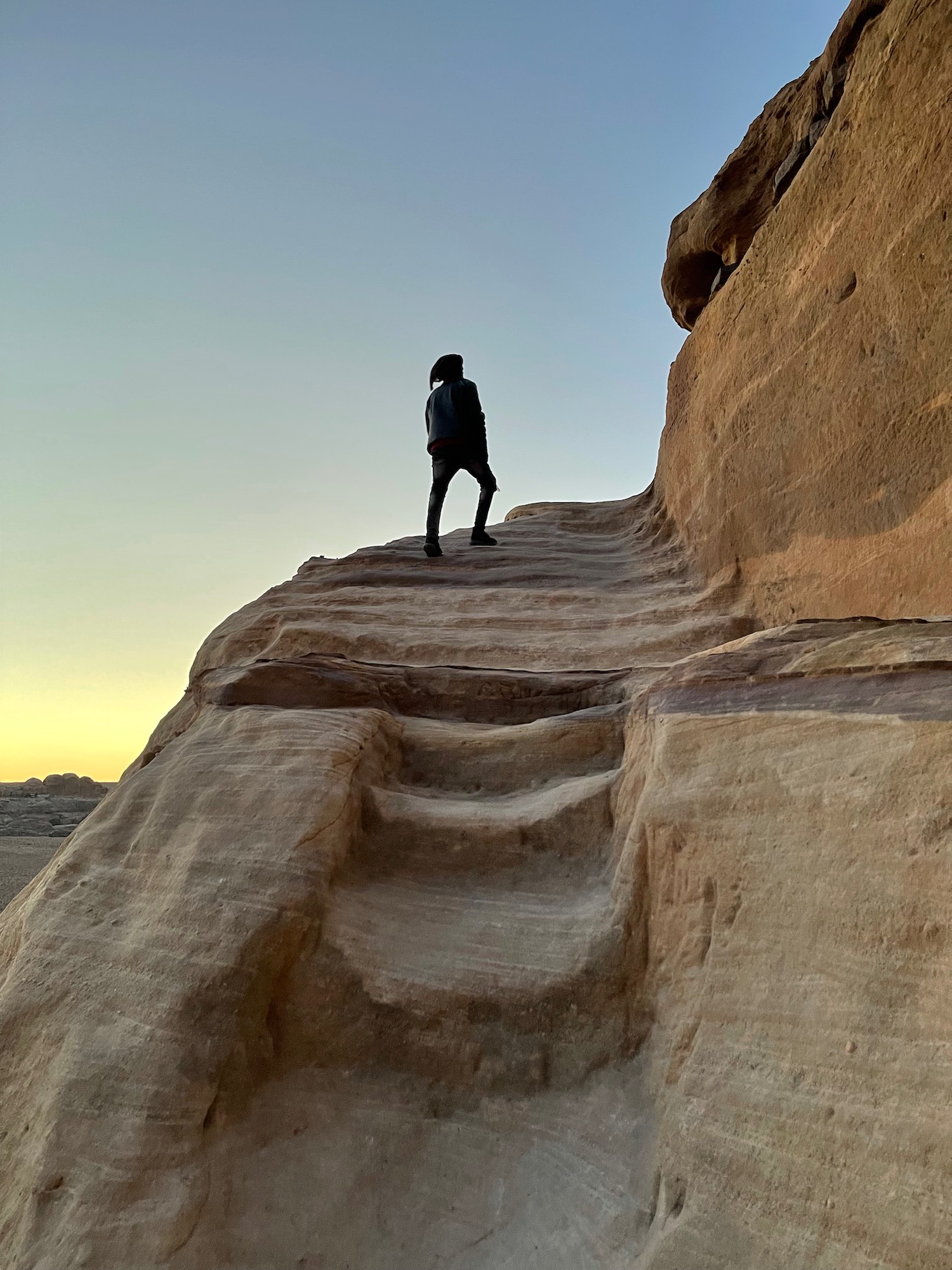 a person walking up a rocky cliff