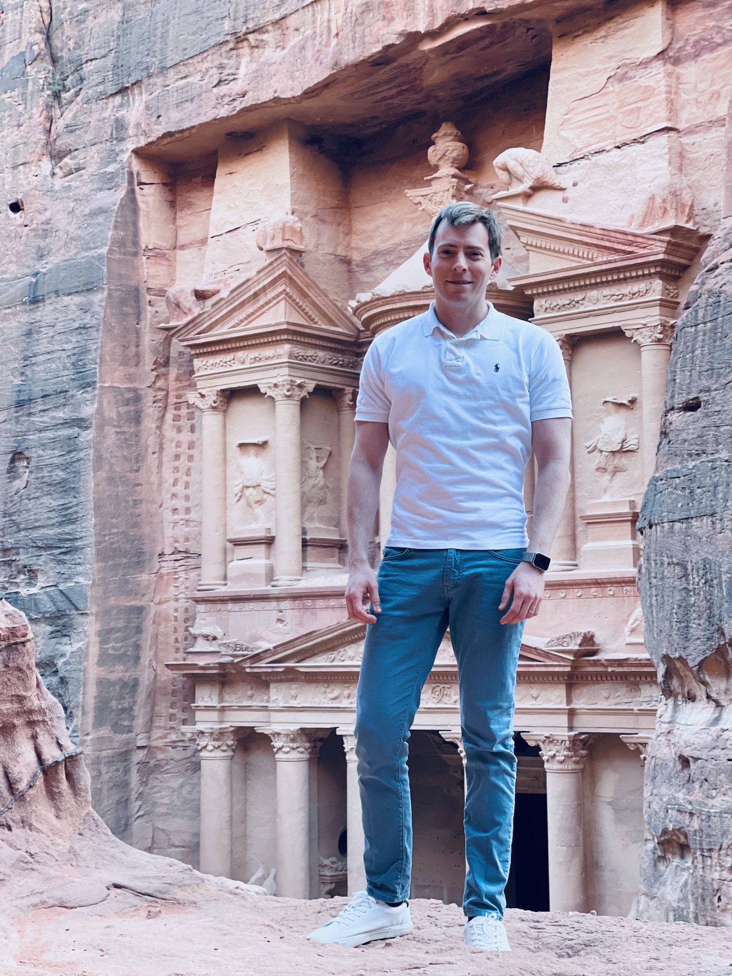 a man standing in front of a rock structure