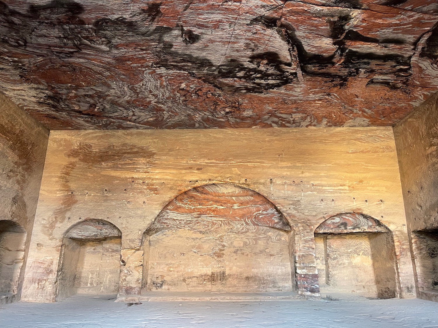 a stone wall with arches and a ceiling