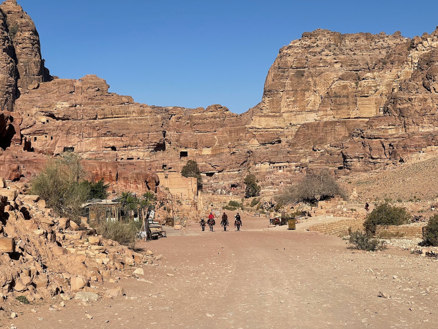 a group of people riding horses in a rocky area