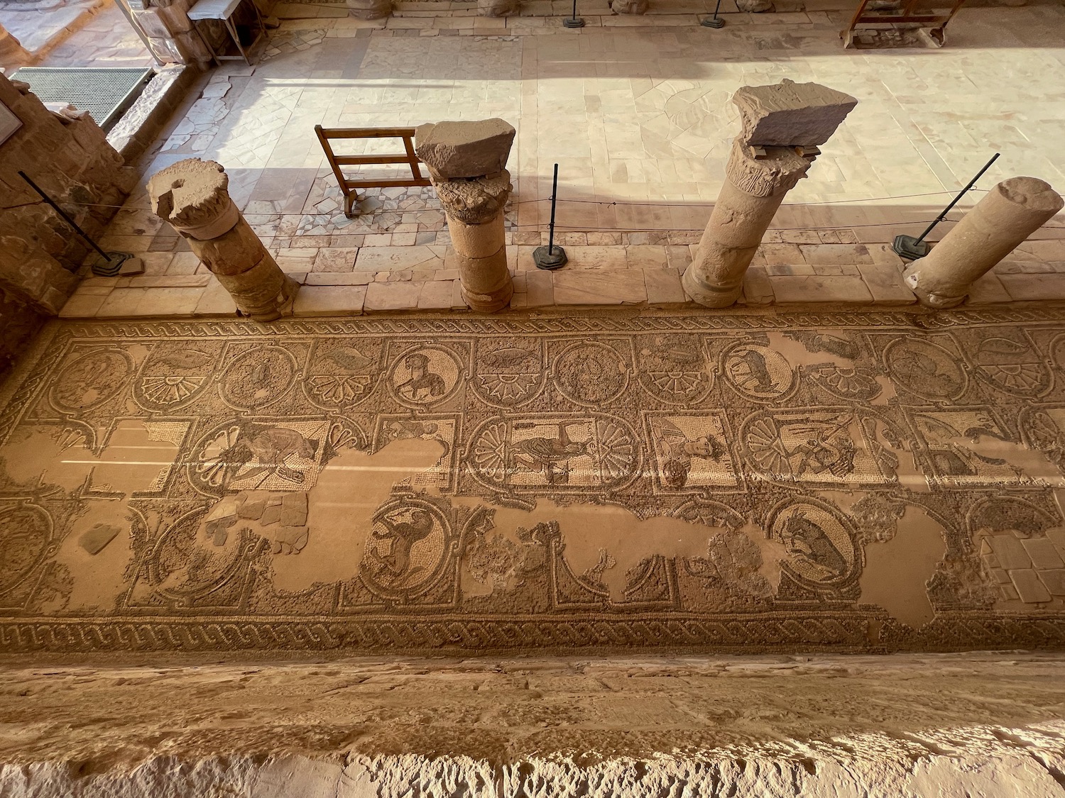 a stone floor with a rug and columns