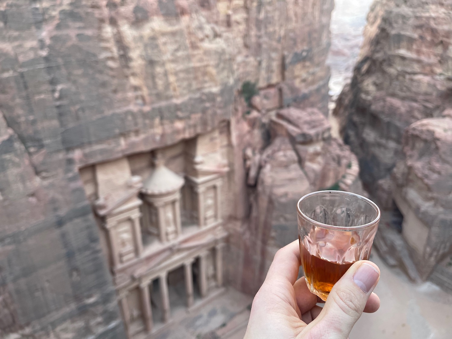 a hand holding a glass of alcohol