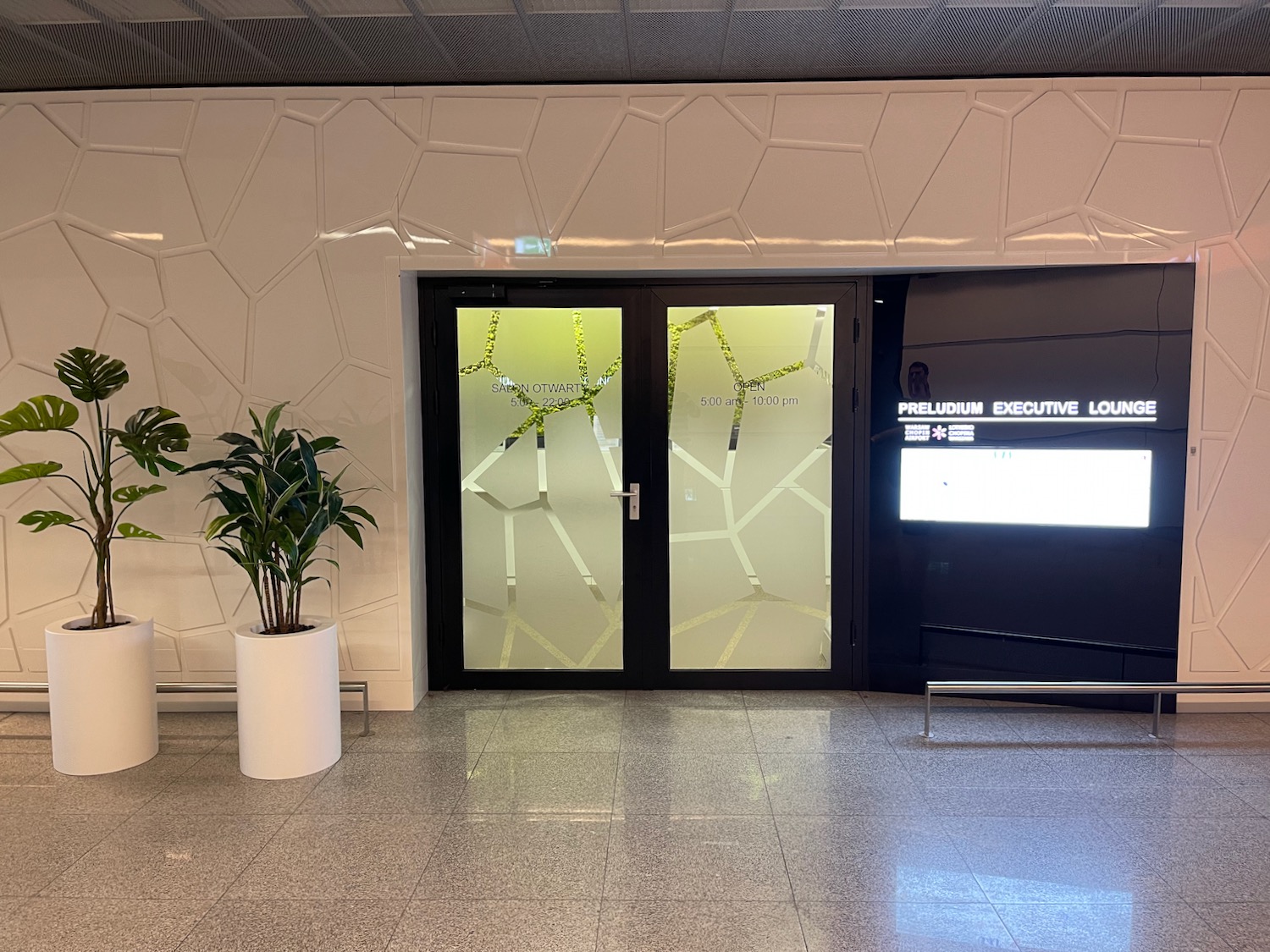 a glass doors with a plant in front of it