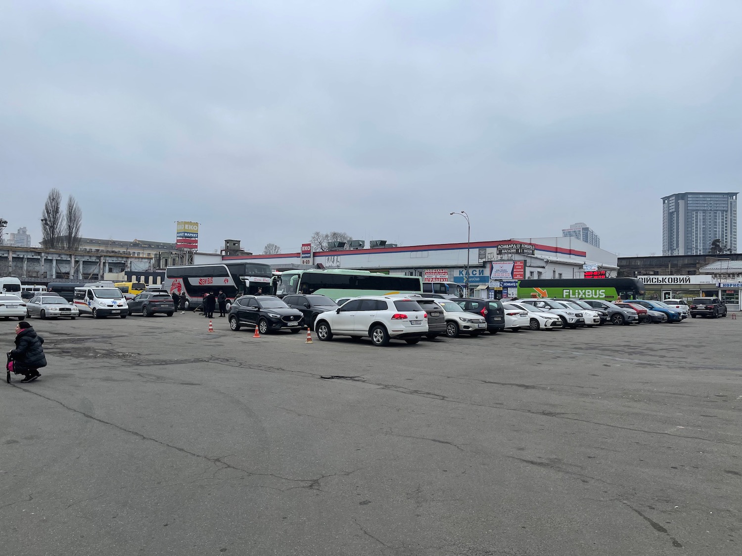 a parking lot with cars and people