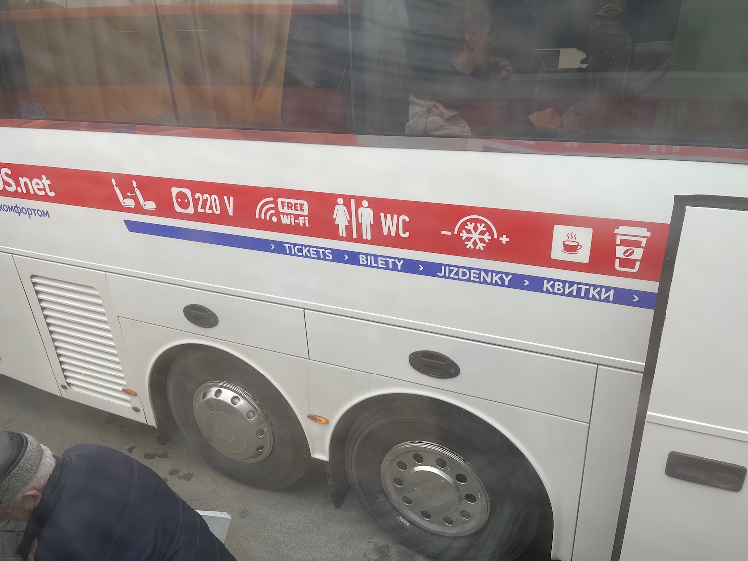 a white bus with red and blue writing