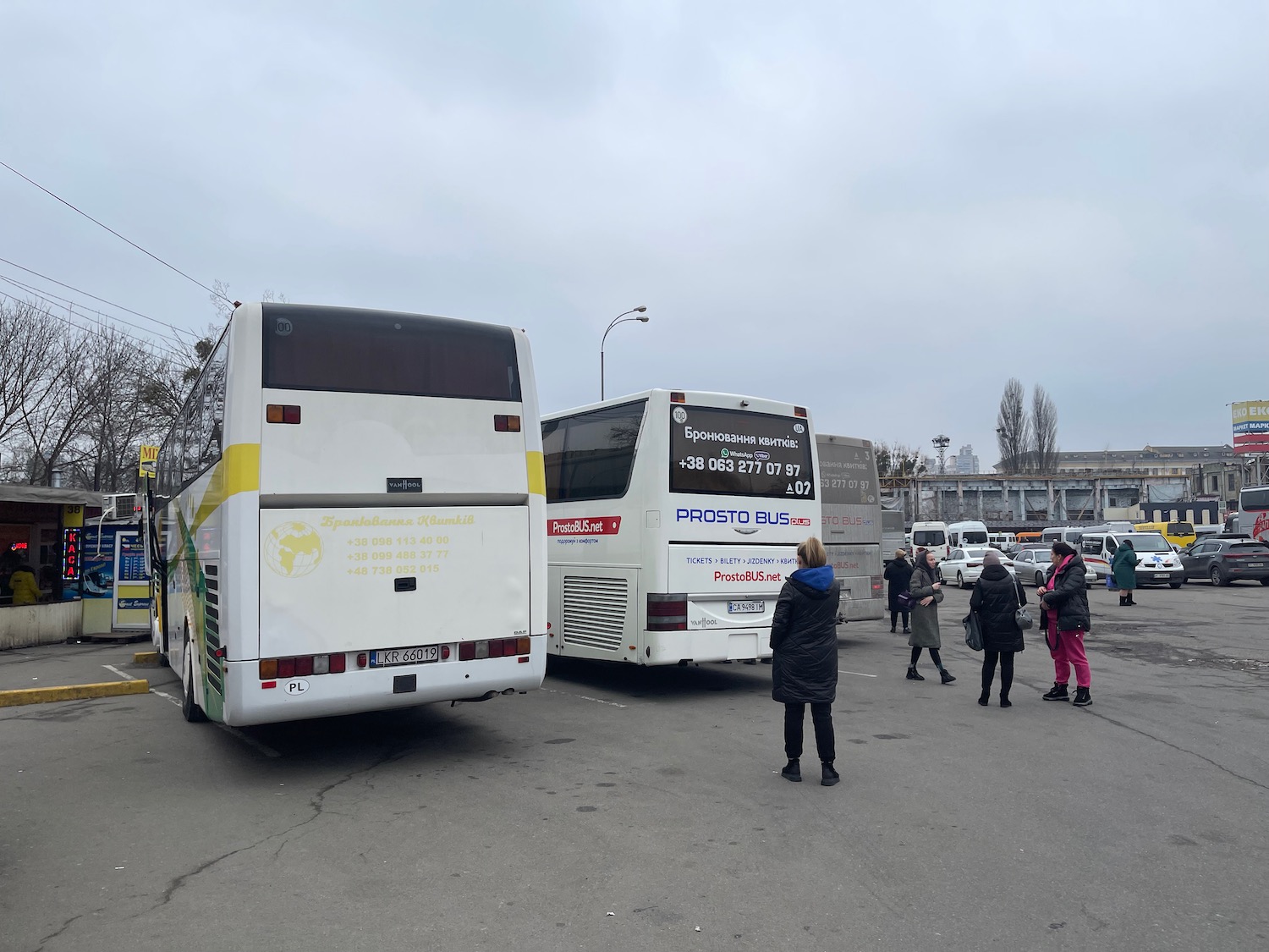 a group of people standing next to buses