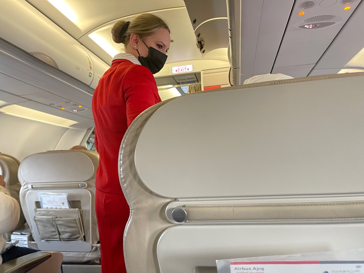 a woman wearing a black face mask on an airplane