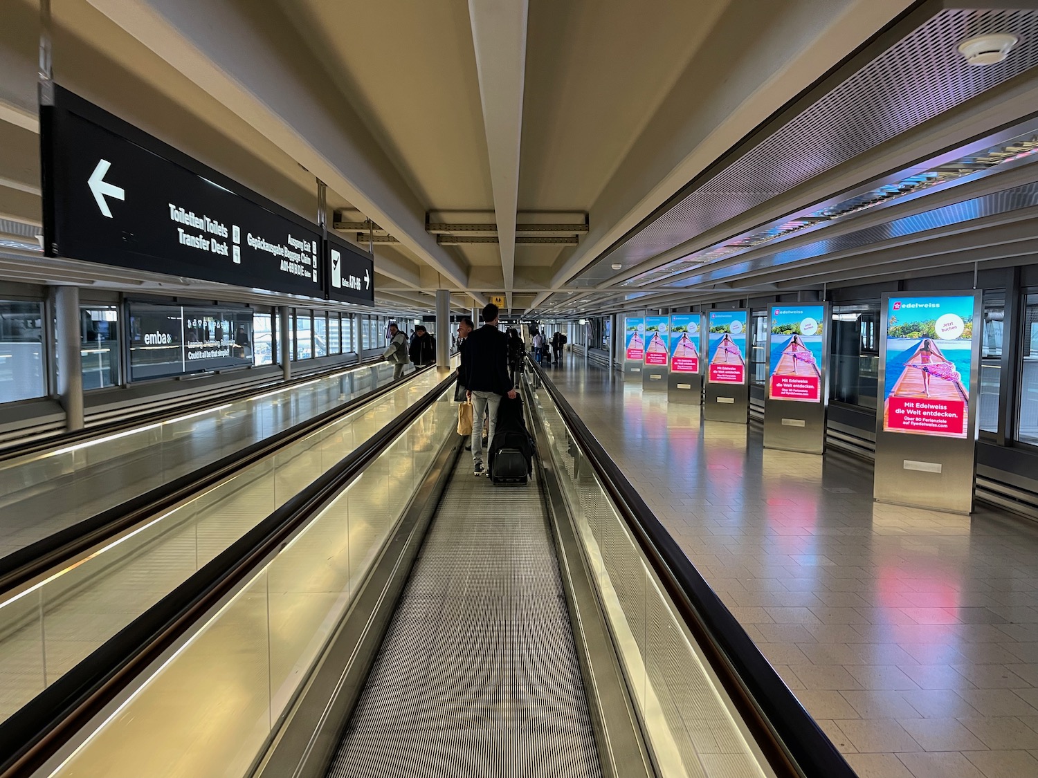 a group of people walking on an escalator