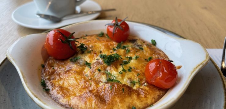 a bowl of food with tomatoes on top