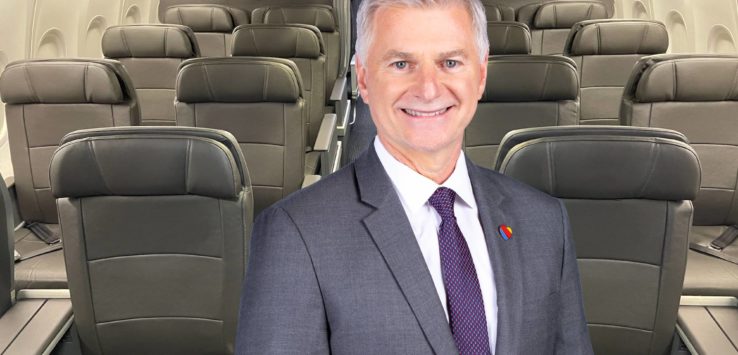 a man in a suit and tie standing in an airplane