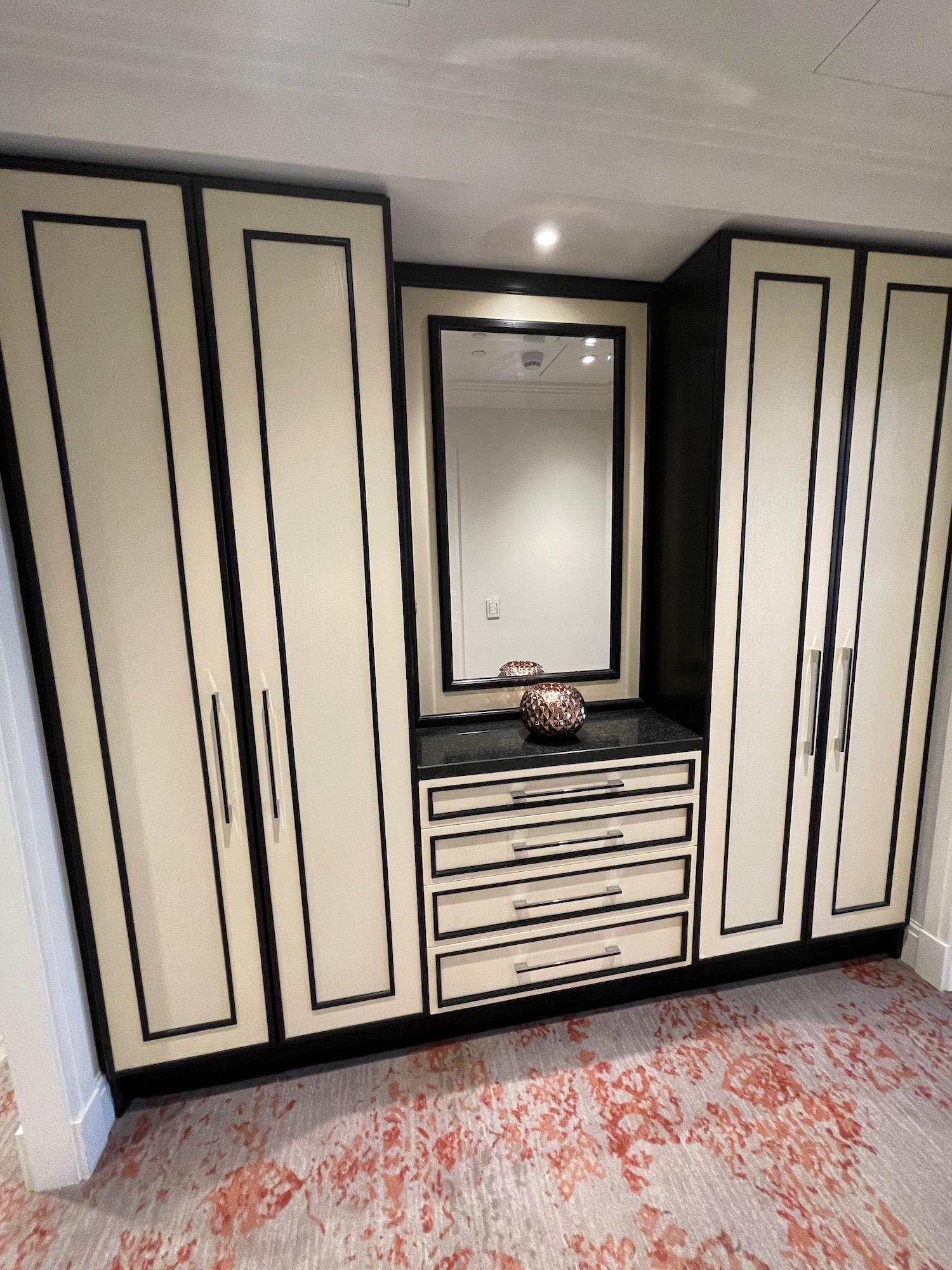 a white and black closet with a mirror